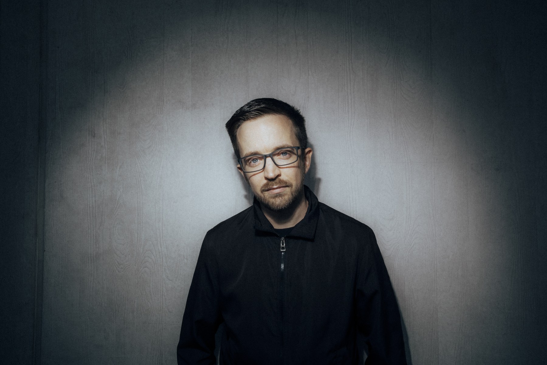 DJ Luke im Studio vor einer grauen Wand